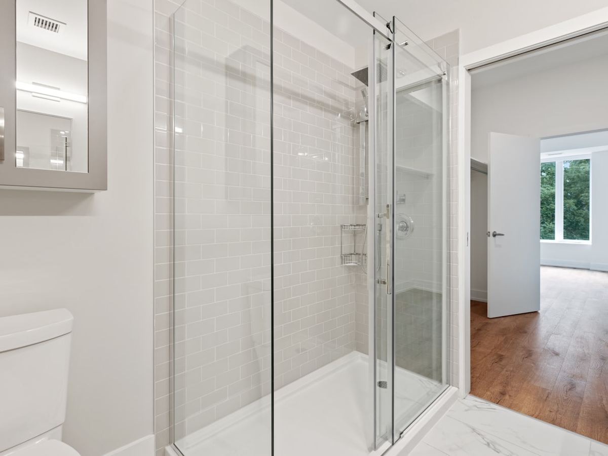 Frameless glass shower door installed in a remodeled residential bathroom